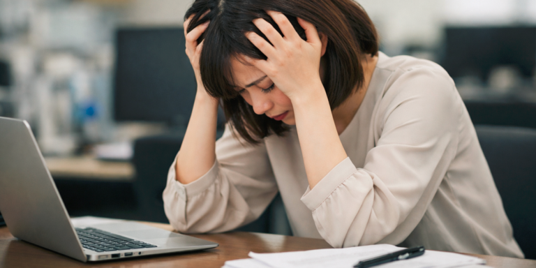 仕事のミスで頭を抱える女性社員