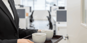 応接室の前でお茶出しをする準備をしている女性社員