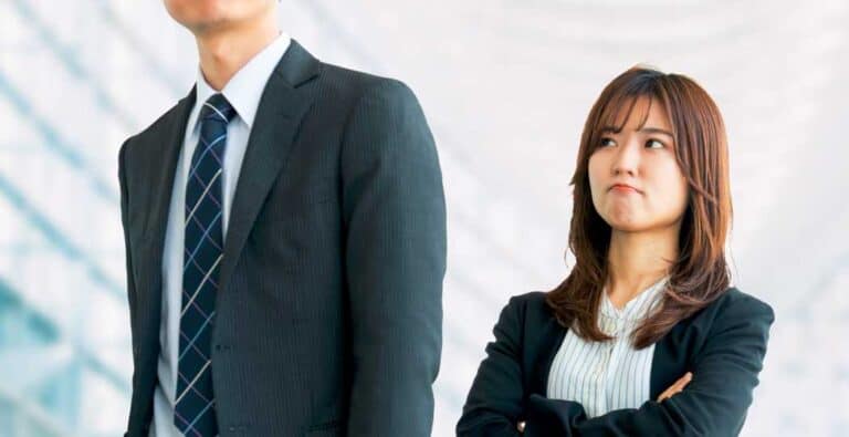 不満そうに男性社員を見つめる女性社員