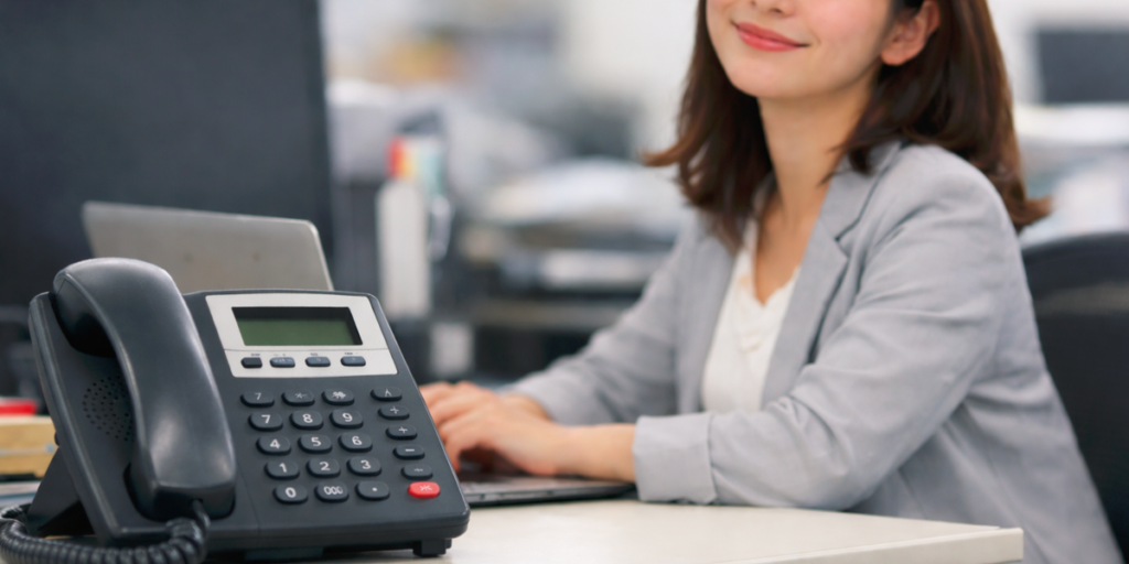 a_female_employee_smiling_while_looking_at_the_phone 電話を見てほほ笑む女性社員