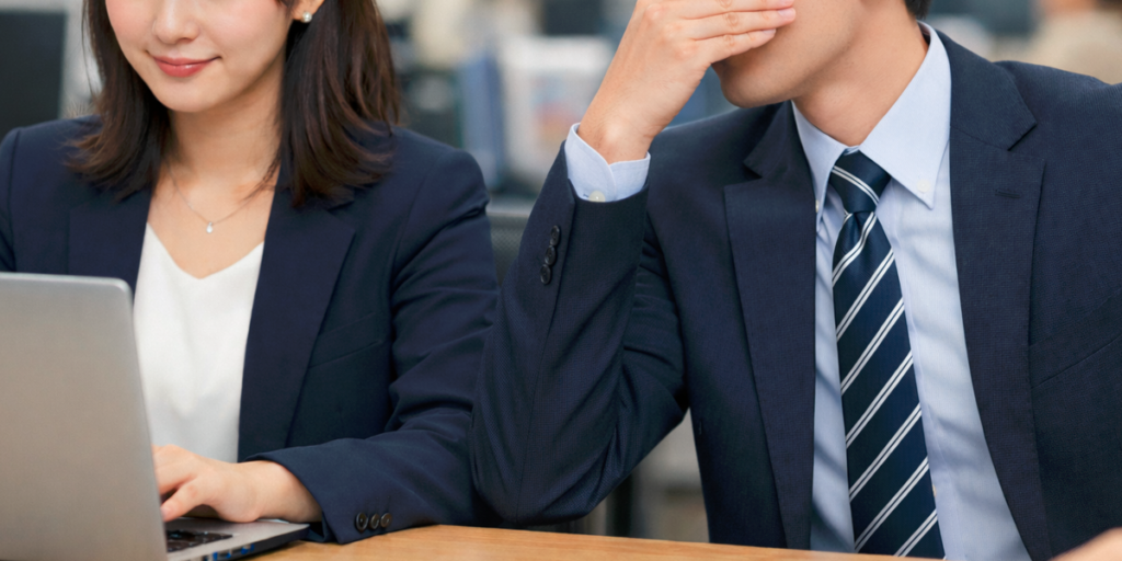 a_male_employee_holds_his_nose_because_of_the_strong_scent_of_a_female_employee. 女性社員の香りが強くて鼻を抑える男性社員