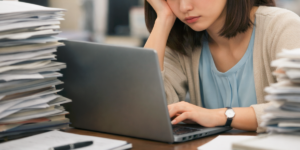 パソコンをみながら悩む女性社員